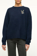 Navy cashmere crewneck sweater with embroidered insect emblem at right chest