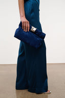Cobalt suede cuff clutch with silver-tone front clasp, hand-held