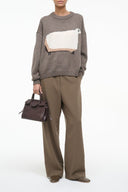 Dark knit sweater with oversized front pocket graphic patch and crew neck