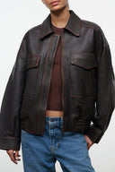Distressed brown leather jacket with collar, zip front, and flap chest pockets