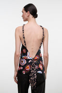 Back view of black sleeveless silk top with open back and circular multicolor print