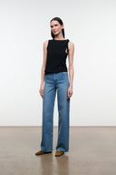 Black sleeveless top with asymmetrical drape and tied shoulder detail