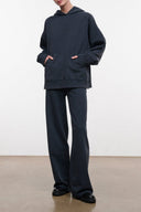 Washed black terry hoodie with front pocket and drawstring hood, loose fit.