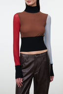 Fitted brown and black sleeveless top with mock neck, long red sleeves