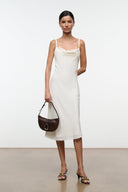 Crisscross strap mule sandals with low heel worn with a white midi dress and bag
