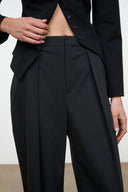 High-rise tailored pants close-up, buttoned waistband and pleated front