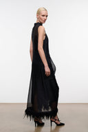 Black sleeveless dress, side view, with sheer panel and feathered hem trim