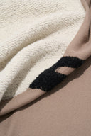 Sherpa-textured underside of truffle taupe throw with black paw print design