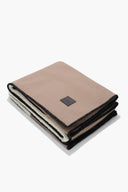 Truffle taupe throw blanket folded with black stitched edging and label
