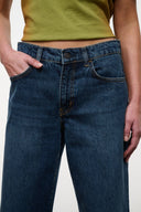 Relaxed-fit dark blue jeans with button fly, belt loops, and front pocket stitching.
