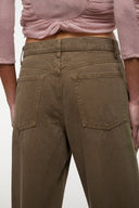 Relaxed olive jeans front detail with two patch pockets and stitched seams