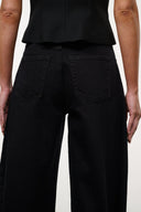 Jet black barrel-leg jeans with front patch pockets and center seam
