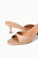 Cashew open-toe mule with crossover straps and cushioned footbed, close-up