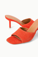 Pair of orange suede open-toe mules with slim stiletto heels and crossover upper.