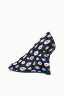 Heel-side view of peep-toe wedge shoe with dark floral print upper