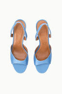 Pair of light blue satin slingback heels with open toe and ankle strap