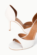 White pointed-toe stiletto heeled sandals with tan-lined cutout strap detail
