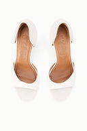 Pair of white stiletto heeled sandals with open toe and tan interior lining