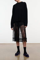 Tabi socks on feet in black with split toe design, worn under a sheer skirt