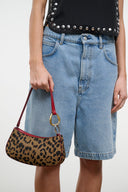 Close view of OLLIE bag on burgundy handle with cheetah print body and gold ring