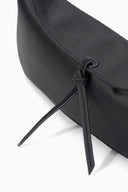 Black clutch closure detail with braided cord tie and loop hardware