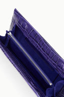 Purple croc-embossed clutch interior with zippered pocket and stitched lining