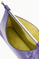 Purple croc clutch open to reveal yellow lining and silver bar hardware