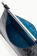 Open black croc-embossed clutch with metal bar frame and blue suede interior lining.