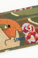 Beaded fabric panel with orange and floral motifs and partial blue text.