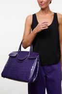 Purple croc carryall bag with curved top handles and front snap-flap