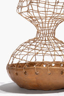 Ceramic twine sculpture close-up: mesh body with tan band and small grommet details