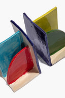 Ceramic bookends with teal and dark blue back panels and red arched front.