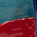 Ceramic bookend with glossy red glaze and blue glazed edge detail.