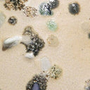 Speckle-glaze ceramic close-up with dark, multicolor raised dots and swirls