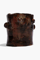 Dark brown ceramic candle holder with sculpted face details and side knobs