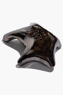 Ceramic ikebana holder with wave-like dark metallic finish and central 9 hole cluster