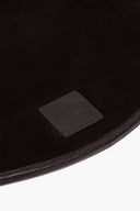 Espresso leather placemat corner with stitched border and embossed logo patch