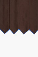 Dark brown linen placemats with pointed hem and blue trim, close-up