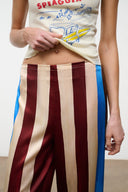 Silk pants with vertical caffe, cream, and blue stripes on a model
