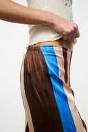Silk pants with vertical brown, blue, beige, and burgundy stripes, side view