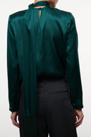 Back view of emerald green satin-like top with high neck and center back seam