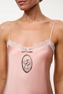 Quartz pink silk dress front with oval emblem and lace-trim spaghetti straps
