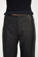 Black leather pants close-up with elastic waistband and center seam stitching