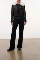 Black leather moto jacket with shearling-trim collar, front zipper, and zip chest pockets