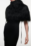 Black fringed faux-fur shrug with draped shoulders and long tie tassels