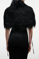 Black faux-fur shrug back view with shaggy texture and long fringe edges