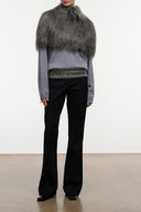 Graphite faux-fur shrug with open drape over heather-gray sweater and black pants