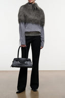 Graphite faux-fur shrug draping over gray sweater; paired with black trousers