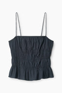 Black sleeveless top with thin straps and tiered ruffle smocking