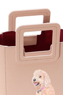 Mini blush leather tote bag with square handles, red lining, and dog graphic